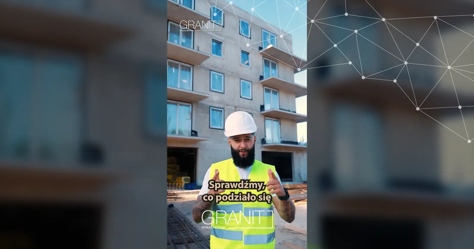 Pracownik GRANIT S.A. w kasku i kamizelce omawia postęp budowy budynku Henry Hudson na tle elewacji.